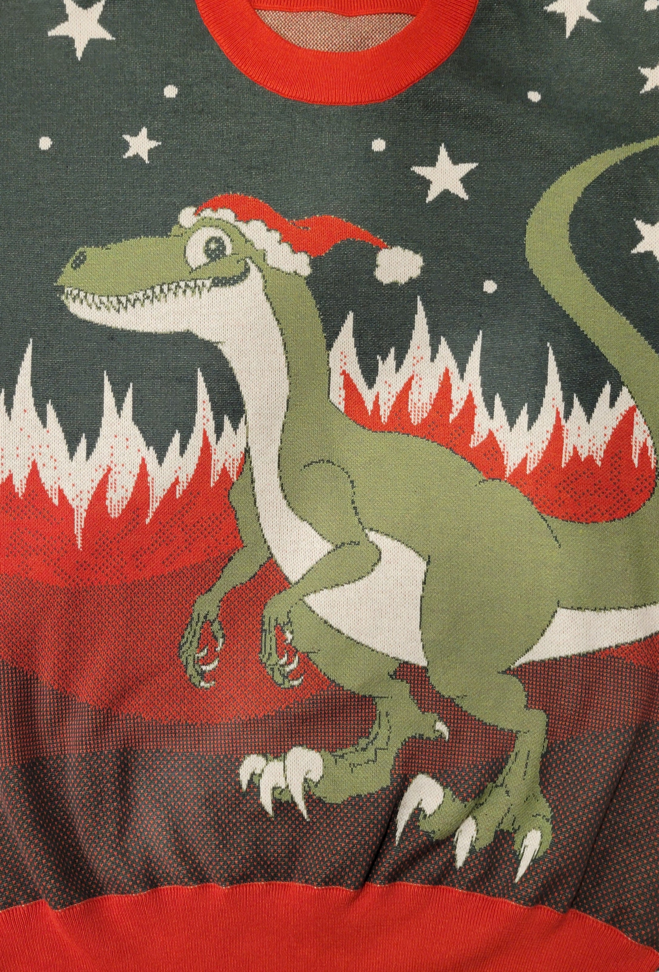 Green dinosaur wearing a Santa hat on a dark green background with red and white elements.